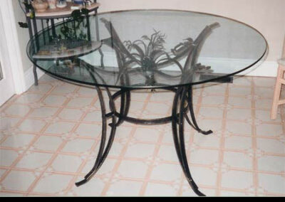 Glass top dining table by Live Iron Forge.